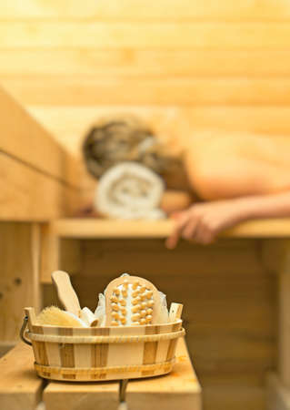 Spa accessories in sauna. Woman on background.の写真素材