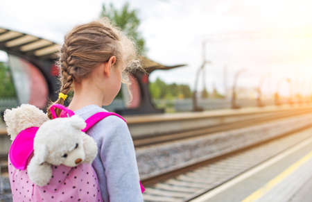 Little girl waiting for train at the railway station.の写真素材
