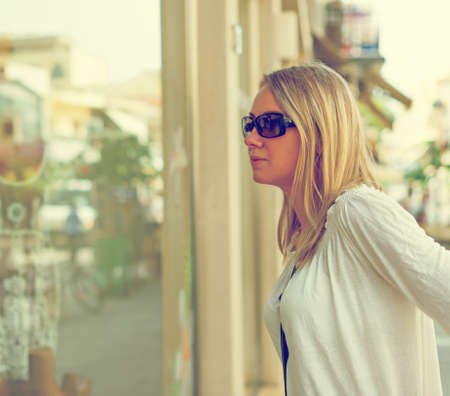 Woman looking at display window in fashion store.の写真素材