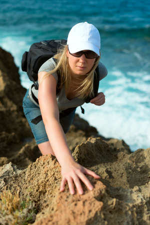 Pretty woman in glasses with backpack hiking in the mountains.の写真素材