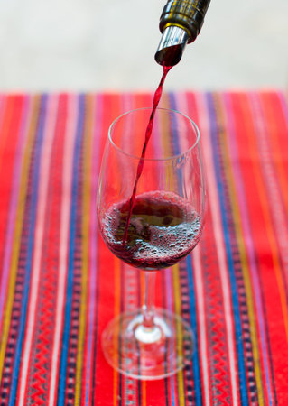 Red wine is pouring into wine glass.の写真素材