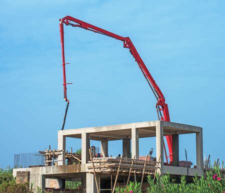 Trailer-mounted boom concrete pump at construction site.の写真素材