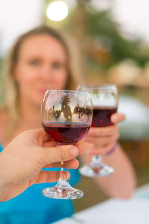 Man and woman clinking their glasses with red wine.の写真素材