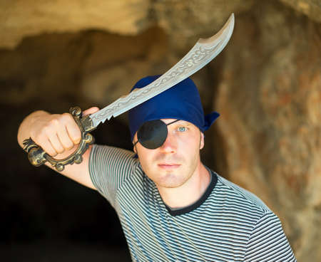 Male pirate with sword near the cave entrance.の写真素材
