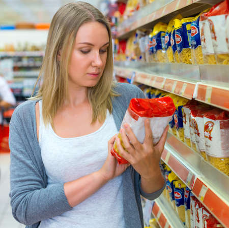 Woman choosing pasta in grocery store.の写真素材
