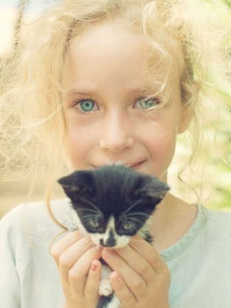 Cute little girl holding little kitten.の写真素材