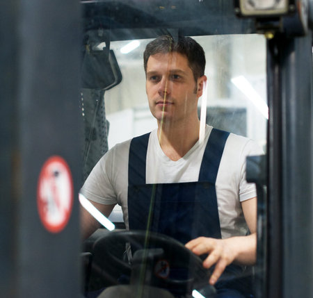 Handsome forklift operator working in the warehouse.の写真素材