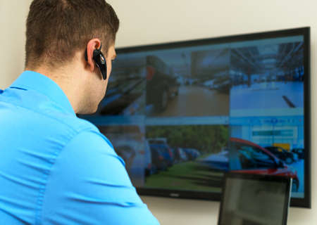 Security guard monitoring video in security room.の写真素材