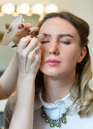 Make-up artist applying makeup on model's face.の写真素材