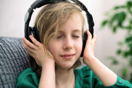Little girl listening to the music in headphones.の写真素材