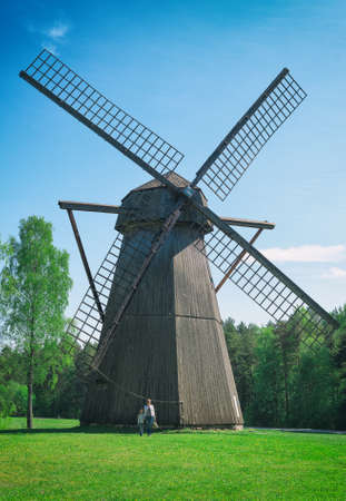 Old estonian windmill with two people. Size matters!の写真素材