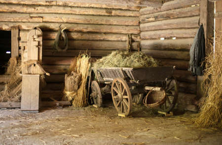 Wooden cart with hay in old barn.の写真素材