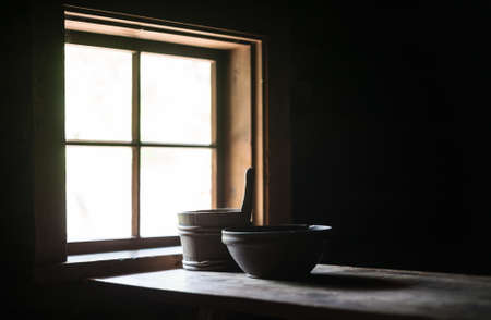 Wooden table with dishes in ancient house.の写真素材