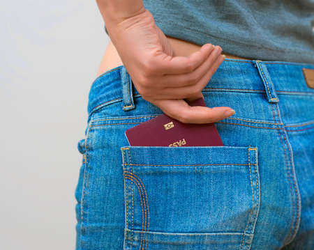 Woman pulls out european passport from his back pocket.の写真素材