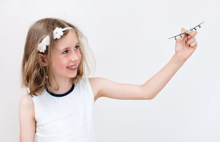 Little girl playing with toy airplane.