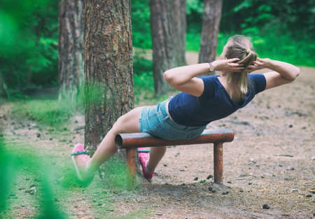 Woman doing abs workout in the forest.の写真素材