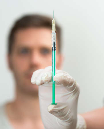 Doctor's hand holding syringe with injection.の写真素材