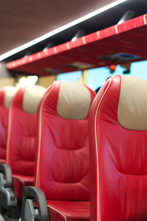 Empty red leather seats in tourist bus.