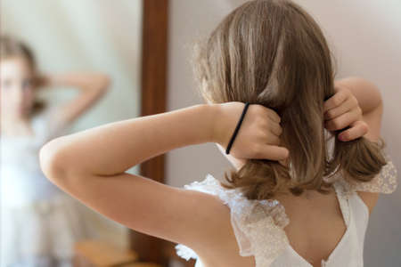 Little girl dresses up in front of the mirror.の写真素材
