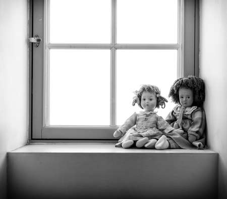 Two dolls near the window. Black and white photo.の写真素材