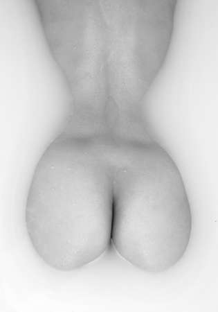 Beautiful woman body in bath with milk. SPA treatments for skin care. Black and white photo.の写真素材