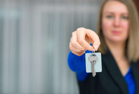 Hotel receptionist offering key from room. Place for text.の写真素材