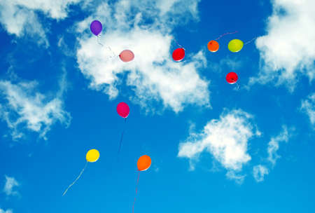 Many colorful baloons in the blue sky.の写真素材