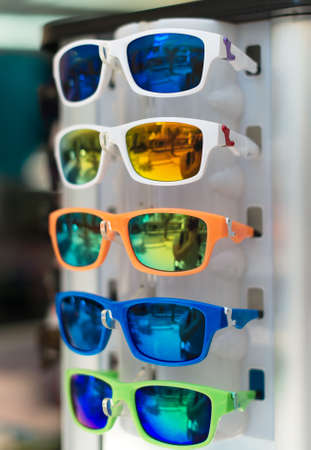 Rotatable rack with colorful sunglasses in market.の写真素材