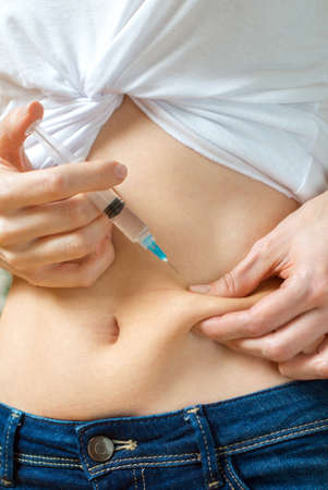 Woman giving herself insulin shot injection.の写真素材