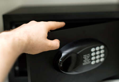 Man's hand opening small safe.の写真素材