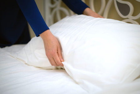 Room service. Woman making bed in hotel room.の写真素材