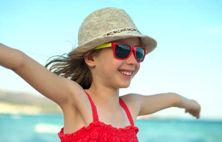 Summer vacation concept. Smiling girl with arms wide open.の写真素材