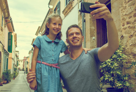 Father and daughter taking selfie in old town. Vintage effect.の写真素材