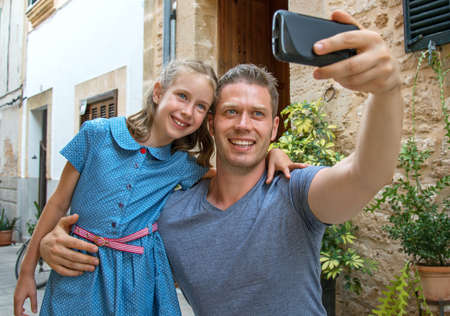Father and daughter taking selfie in old town.の写真素材