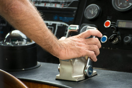 Captain's hand on ship throttle.