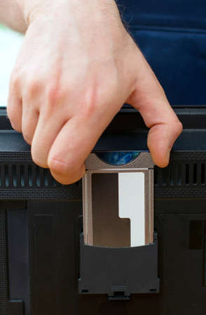 Man installing conditional access module card to TV.の写真素材