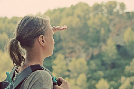 Woman with backpack enjoying view in mountains.