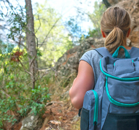 Woman with backpack enjoying nature. Back view.