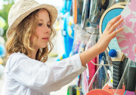 Little girl is choosing table tennis racket for vacations.の写真素材