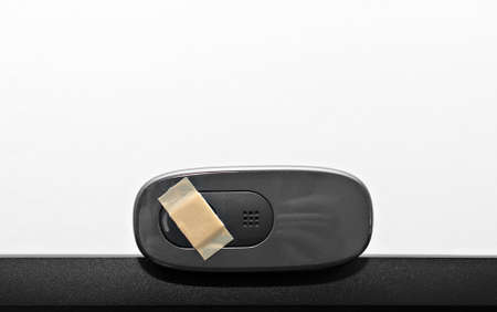 Close-up view of web camera covered with tape.の写真素材