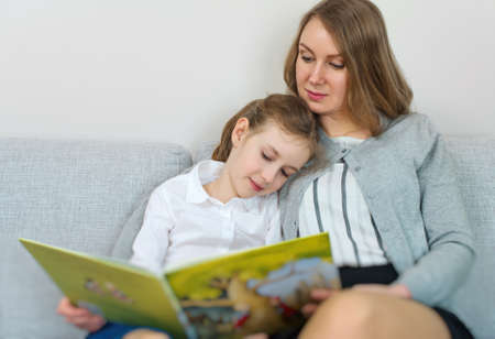Mother and daughter reading a book.の写真素材