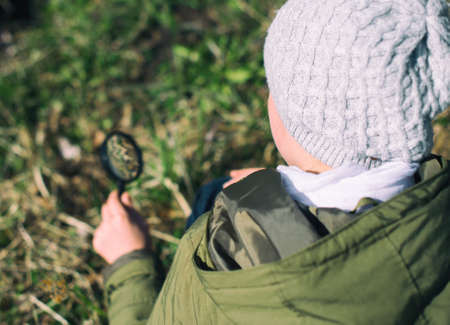Little girl examining nature through the magnifying glass.の写真素材