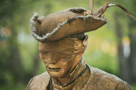 Unrecognizable golden man in mask on street carnival.の写真素材