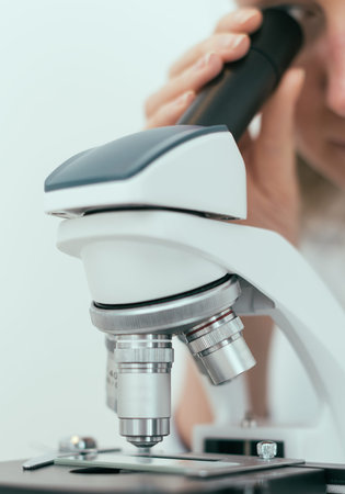 Scientist using microscope in laboratory.
