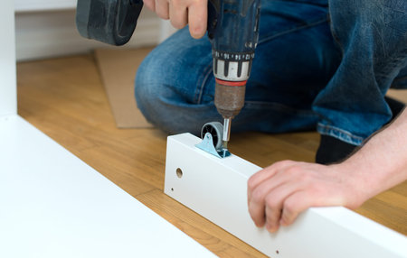 Repairman using screw gun. Close-up view.