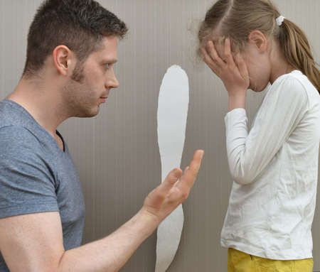 Little girl spoiled the wallpaper and her dad is angry.の写真素材