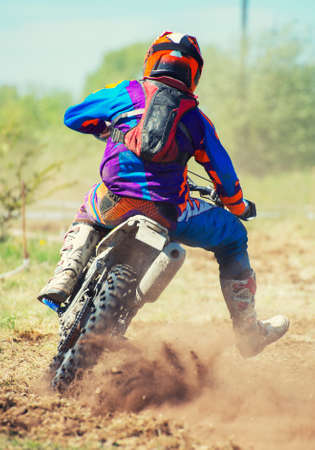 Professional motocross rider on the road. Back view.の写真素材