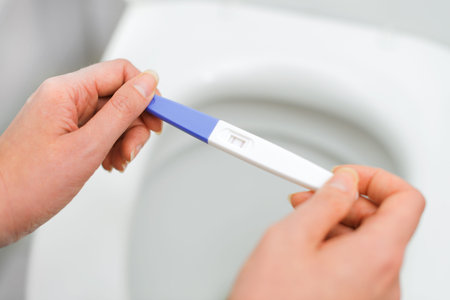 Woman holding positive pregnancy test.