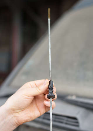 Mechanic measuring the oil level in workshop.の写真素材