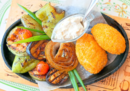Two Chicken Kiev with fried vegetables.の写真素材
